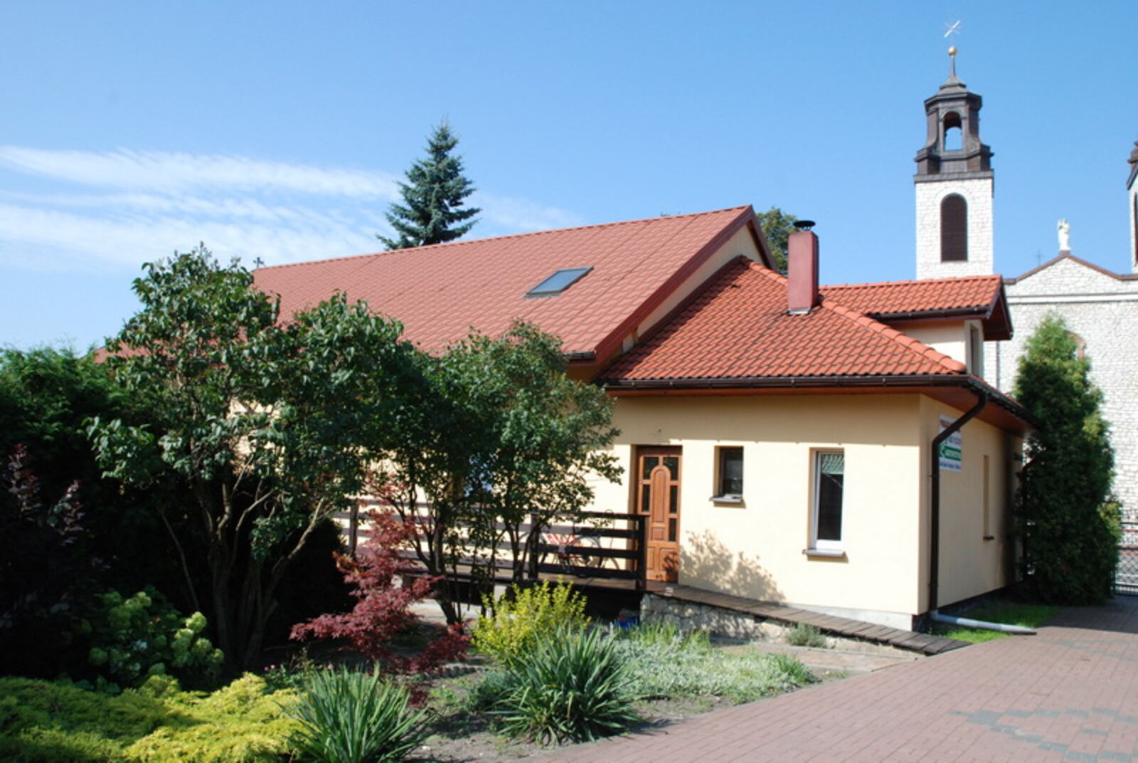 Dom Agroturystyki Lidia Kulak w Kroczycach z ogrodem, w tle wieże kościoła